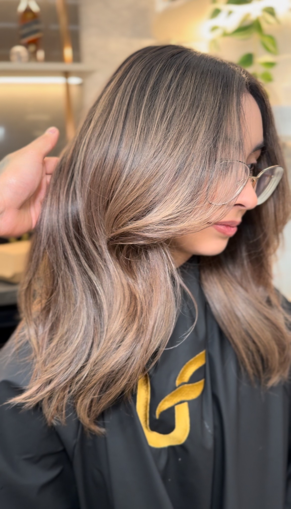 Dimensional colour and a flowing layered haircut, with a client wearing the gold Ultrafade cape